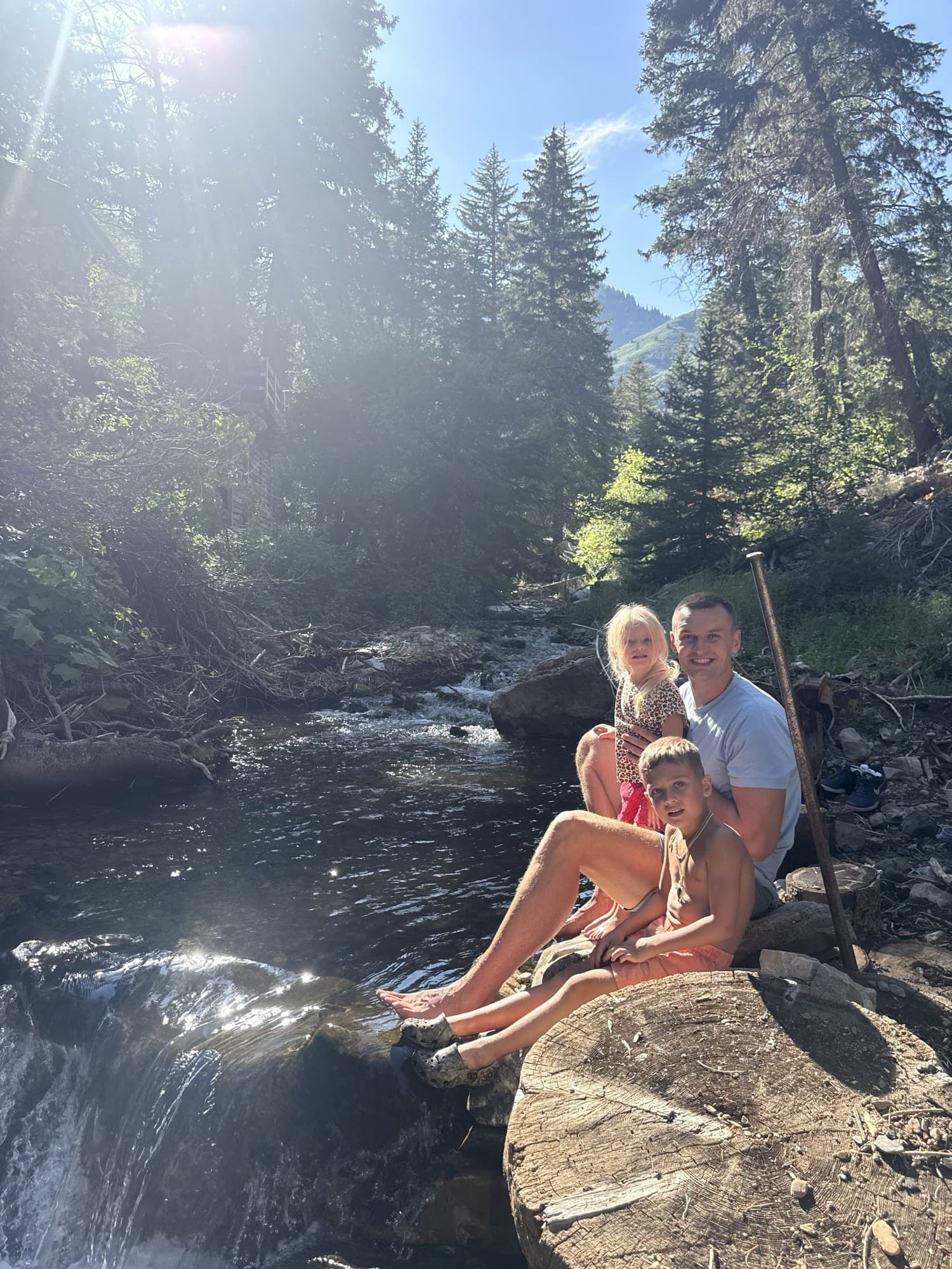 Kyle Collinsworth outdoors with his kids by a mountain stream